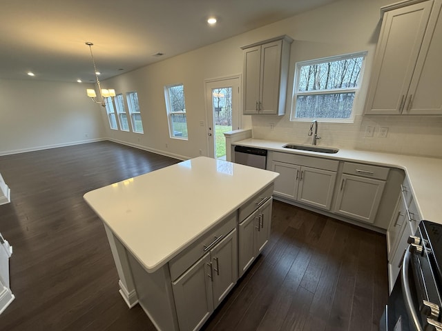 kitchen featuring gray cabinetry, dark hardwood / wood-style floors, sink, stove, and a center island