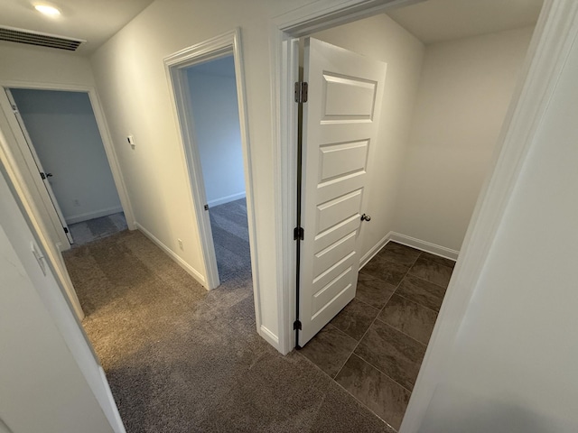 hallway with dark colored carpet