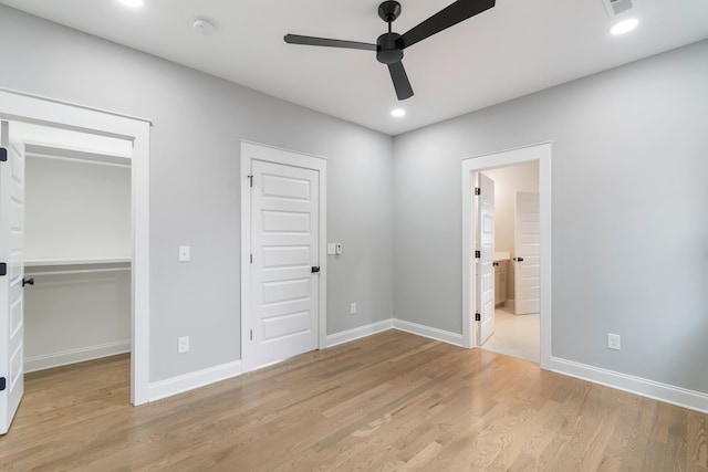 unfurnished bedroom with a closet, light wood-type flooring, ceiling fan, and ensuite bath