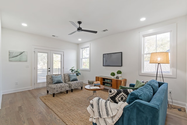 living room featuring ceiling fan, french doors, and light hardwood / wood-style floors