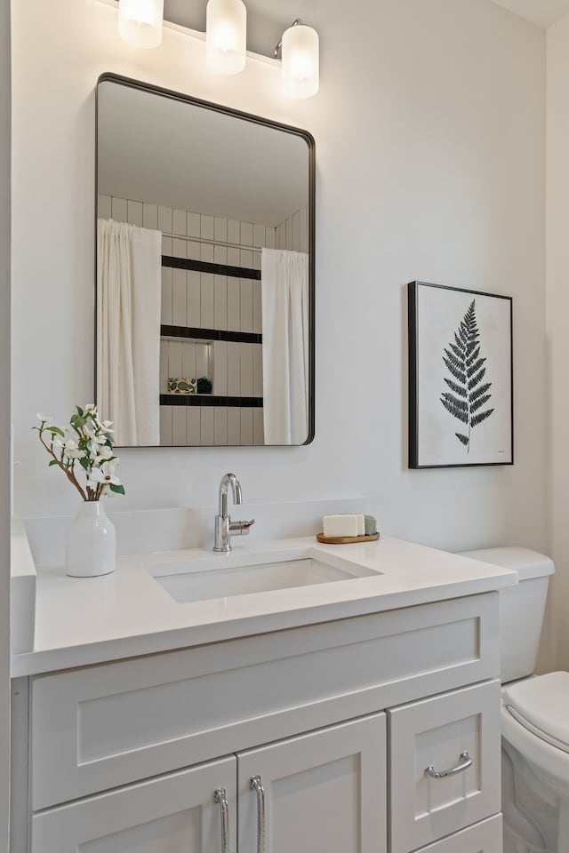 bathroom featuring a shower with shower curtain, vanity, and toilet