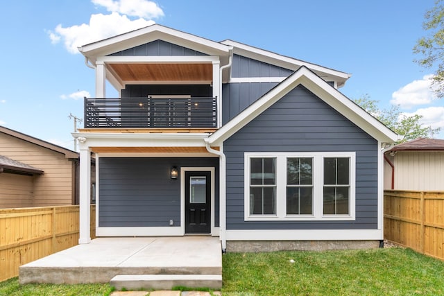 rear view of house featuring a balcony and a patio