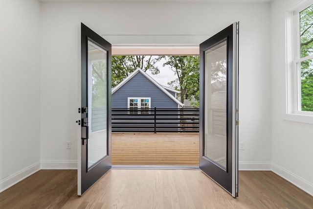 entryway with hardwood / wood-style flooring, french doors, and a healthy amount of sunlight