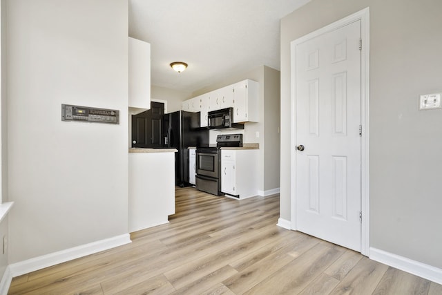 kitchen with white cabinets, light hardwood / wood-style flooring, and black appliances