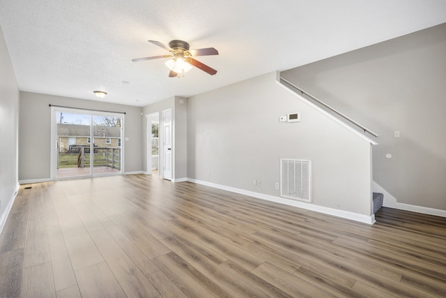 unfurnished living room with wood-type flooring, a textured ceiling, and ceiling fan