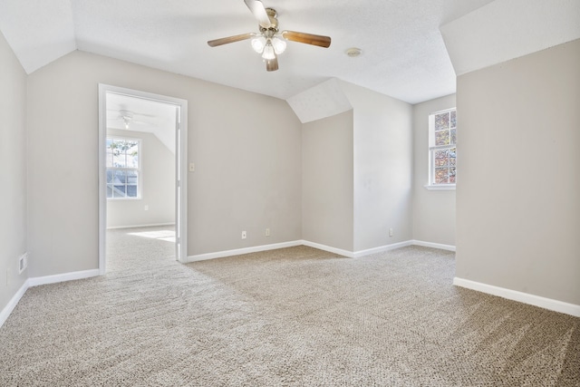 additional living space with light carpet, a textured ceiling, ceiling fan, and lofted ceiling