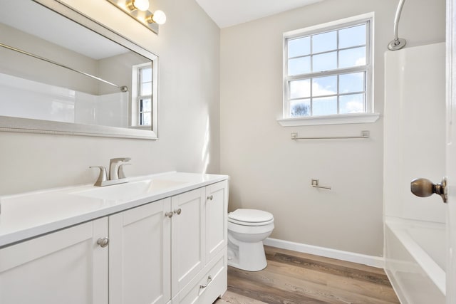 full bathroom with hardwood / wood-style floors, vanity, toilet, and shower / washtub combination