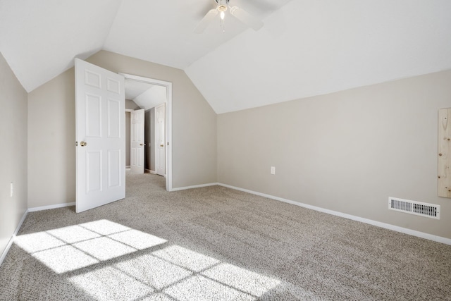 additional living space with ceiling fan, light colored carpet, and vaulted ceiling