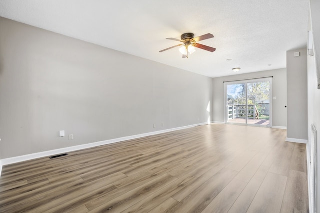 empty room with ceiling fan, a textured ceiling, and light hardwood / wood-style flooring