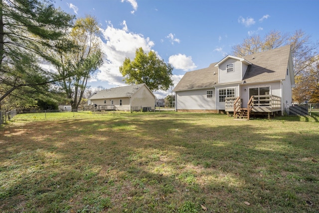 rear view of house with a yard and a wooden deck