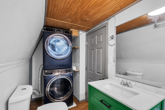 washroom featuring hardwood / wood-style flooring, wood ceiling, sink, and stacked washer and clothes dryer