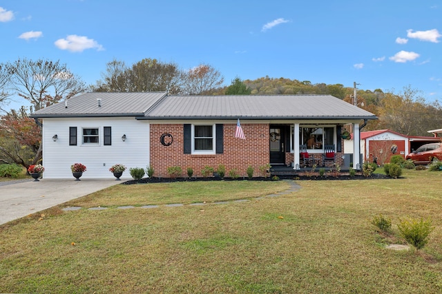 ranch-style house featuring covered porch, a shed, and a front yard