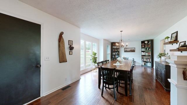 dining room with a chandelier, a textured ceiling, and dark hardwood / wood-style floors