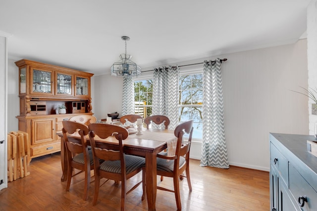 dining space featuring light hardwood / wood-style flooring, a chandelier, and crown molding