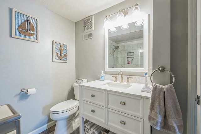 bathroom with toilet, an enclosed shower, and vanity