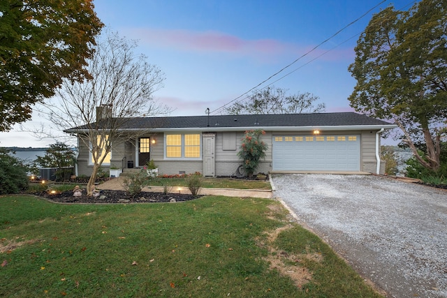 ranch-style house with a garage and a lawn