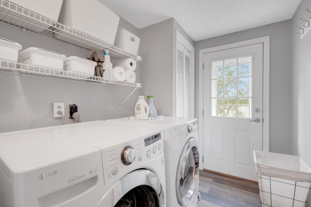 laundry area with separate washer and dryer, wood-type flooring, and a textured ceiling