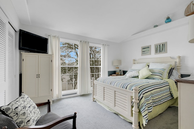 bedroom featuring light colored carpet and vaulted ceiling