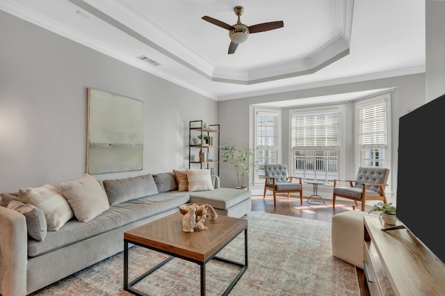 living room with ceiling fan, a wealth of natural light, crown molding, and light hardwood / wood-style flooring