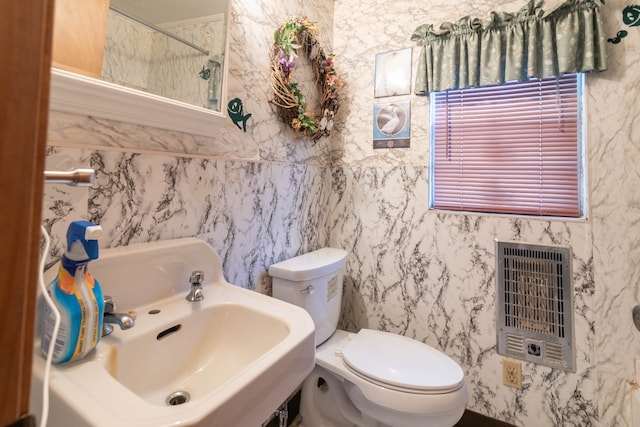 bathroom featuring toilet and heating unit