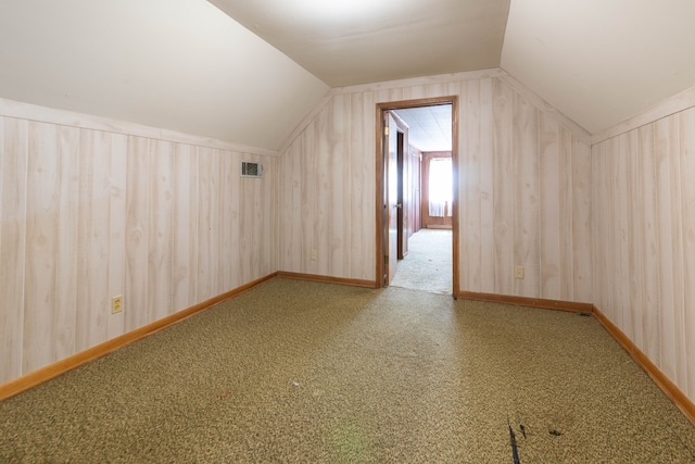 bonus room featuring wooden walls and vaulted ceiling