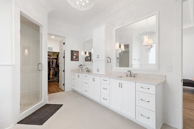 bathroom with an enclosed shower, a chandelier, wood-type flooring, and ornamental molding