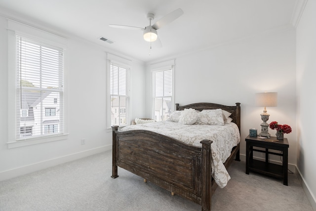 bedroom with ornamental molding, light colored carpet, and ceiling fan