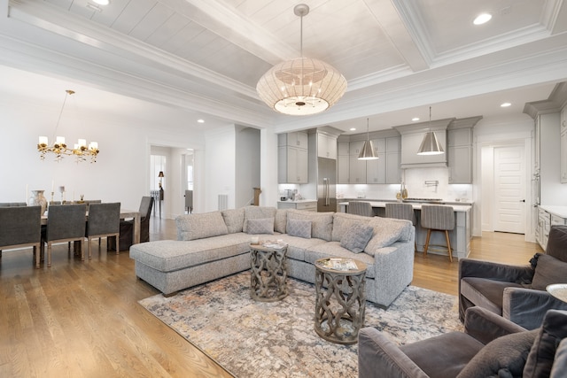 living room featuring light hardwood / wood-style floors, beam ceiling, an inviting chandelier, and crown molding