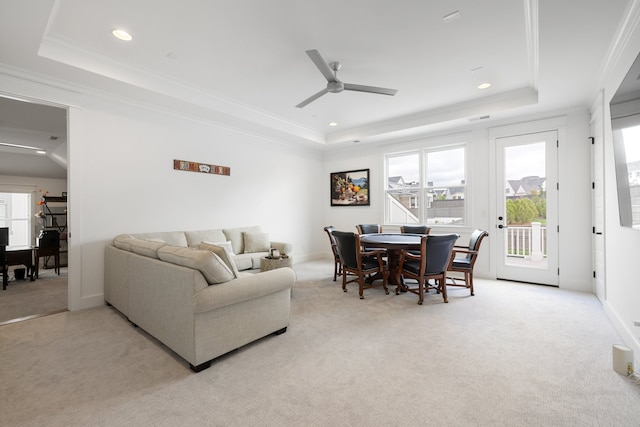 carpeted living room featuring ceiling fan, a tray ceiling, and a healthy amount of sunlight