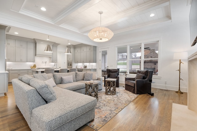 living room with light hardwood / wood-style flooring, beamed ceiling, and crown molding