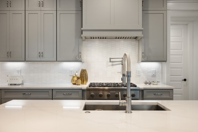 kitchen with gray cabinets and tasteful backsplash