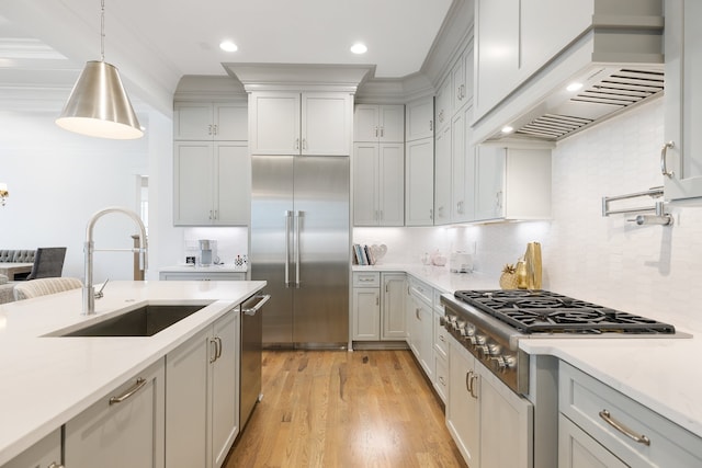 kitchen featuring custom range hood, appliances with stainless steel finishes, sink, and backsplash