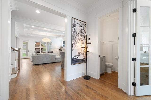 corridor with wood-type flooring and crown molding