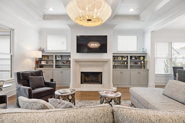 living room featuring a premium fireplace, hardwood / wood-style floors, a healthy amount of sunlight, and crown molding