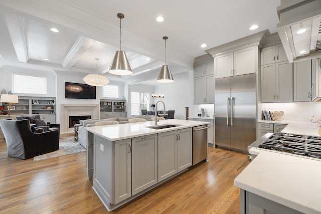 kitchen with sink, appliances with stainless steel finishes, pendant lighting, gray cabinetry, and light wood-type flooring