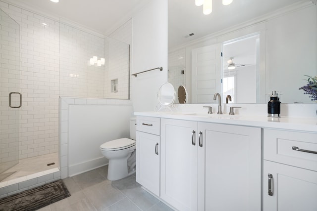 bathroom featuring vanity, tiled shower, crown molding, tile patterned floors, and toilet