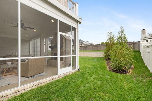 view of yard with ceiling fan, a sunroom, and a patio area