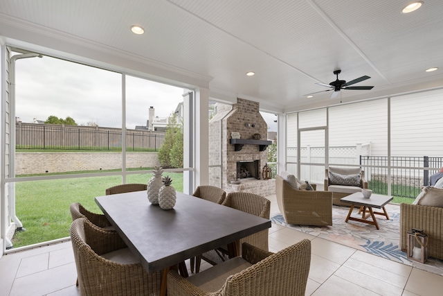 sunroom / solarium with ceiling fan and an outdoor stone fireplace