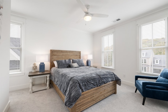 carpeted bedroom with ornamental molding, multiple windows, and ceiling fan