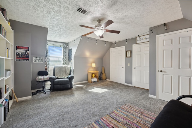 sitting room with carpet floors, lofted ceiling, a textured ceiling, and ceiling fan