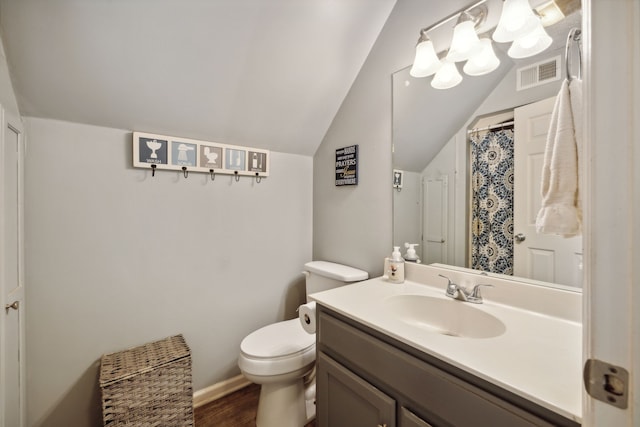 bathroom featuring hardwood / wood-style floors, vanity, toilet, and vaulted ceiling