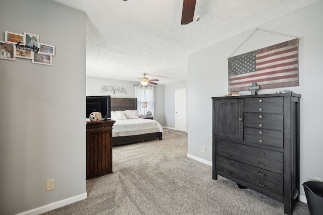 carpeted bedroom featuring ceiling fan and a textured ceiling