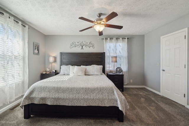 bedroom with a textured ceiling, ceiling fan, and dark carpet