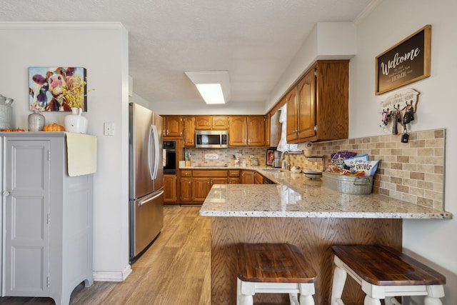 kitchen featuring kitchen peninsula, stainless steel appliances, and a kitchen breakfast bar