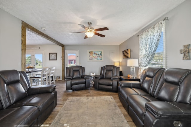 living room featuring hardwood / wood-style floors, a textured ceiling, and ceiling fan