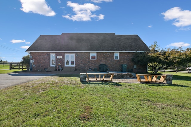 back of house with french doors and a yard