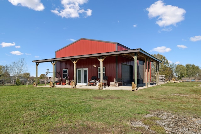 back of property featuring an outdoor structure and a lawn