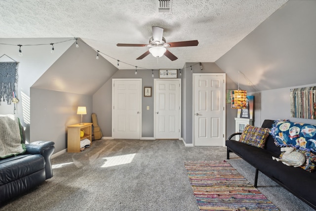 living room featuring carpet floors, a textured ceiling, ceiling fan, and vaulted ceiling