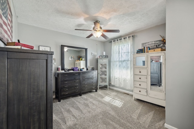 carpeted bedroom featuring a textured ceiling and ceiling fan