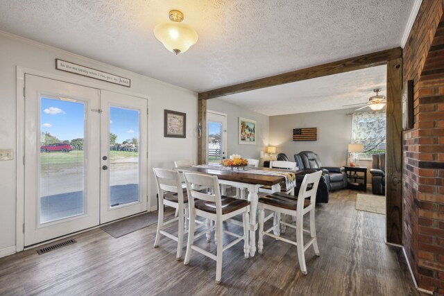 dining room with french doors, dark wood-type flooring, and a textured ceiling